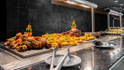 a buffet line of food in a restaurant kitchen at African Sky Ermelo Inn in Ermelo
