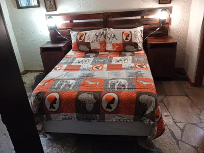 a bedroom with a bed with a quilt on it at Bellamia in Marloth Park