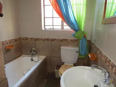 a bathroom with a tub and a toilet and a sink at Bellamia in Marloth Park