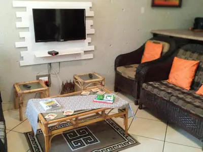 a living room with two couches and a tv at Bellamia in Marloth Park