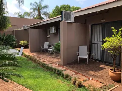 a patio outside of a house with chairs at Odelia Guest House in Mokopane