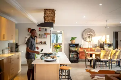 a man standing in a kitchen with a stove at Rafiki Bush Lodge in Hoedspruit