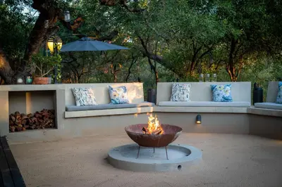 a fire pit in the middle of a courtyard with couches at Rafiki Bush Lodge in Hoedspruit