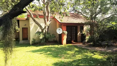 a house with a clock on the front of it at Raka Cottage in Nelspruit