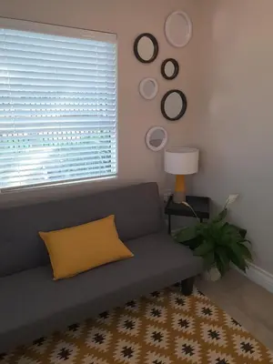 a living room with a couch and a window at NOOii - Flatlet in Pretoria