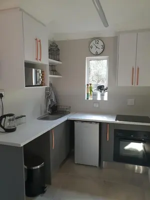 a kitchen with a counter and a clock on the wall at NOOii - Flatlet in Pretoria