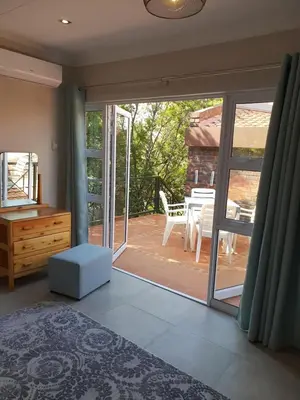 a bedroom with a sliding glass door to a patio at NOOii - Flatlet in Pretoria