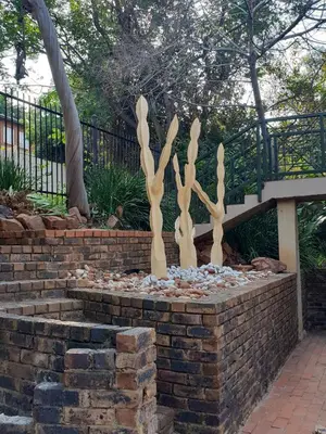 a sculpture of trees on a brick wall at NOOii - Flatlet in Pretoria