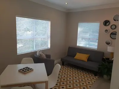 a living room with a couch and a table at NOOii - Flatlet in Pretoria
