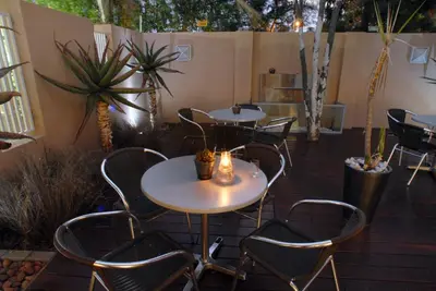 a patio with tables and chairs and plants at The Lofts in Polokwane