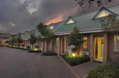 a row of houses at night with a fire in the background at The Lofts in Polokwane