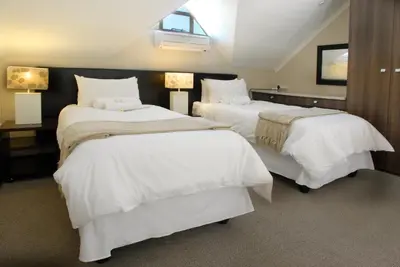 a hotel room with two beds with white sheets at The Lofts in Polokwane
