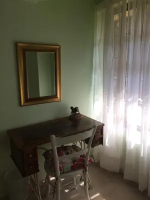 a table with a mirror and a chair next to a window at Air on Edward in Pretoria