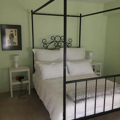 a bedroom with a black bed with white pillows at Air on Edward in Pretoria