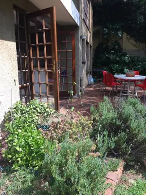 a garden with a patio with a table and chairs at Air on Edward in Pretoria
