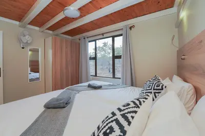 a bedroom with a bed and a window at Hinda Mountain Lodge Mabalingwe in Mabula