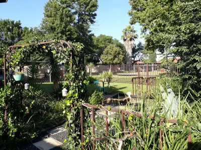 a garden with an arbor with ivy on it at LISANÉ ACCOMMODATION in Middelburg