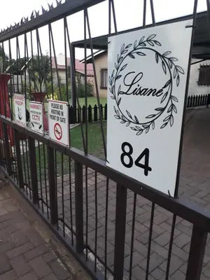 a fence with a sign on it at LISANÉ ACCOMMODATION in Middelburg