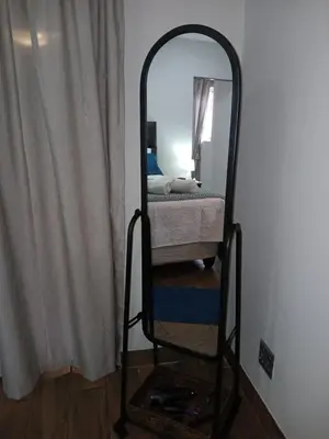 a mirror in the corner of a room with a bed at LISANÉ ACCOMMODATION in Middelburg