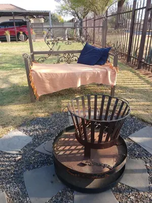 a bed in a park with a bench in a yard at LISANÉ ACCOMMODATION in Middelburg