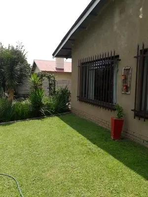 a yard next to a house with a fence at LISANÉ ACCOMMODATION in Middelburg