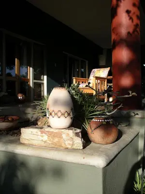 a table with vases and plants on it at Tingala Lodge - Bed in the Bush in Phalaborwa