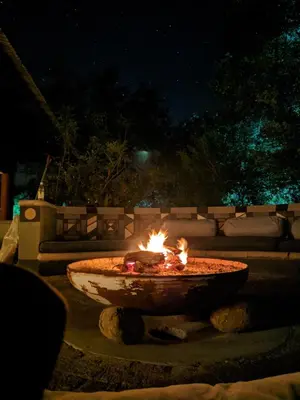 a fire pit in a yard at night at Tingala Lodge - Bed in the Bush in Phalaborwa