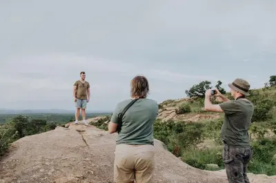 a group of three people standing on top of a rock at Nkambeni Safari Camp in Hazyview