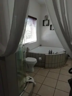 a bathroom with a bath tub and a toilet at Rustic Butler B&B in White River