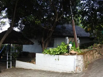 a small white house with a staircase in front of it at Impala Niezel Lodge & Guest House in Hazyview
