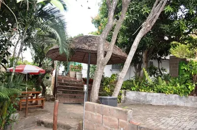 a patio with an umbrella and a table and bench at Impala Niezel Lodge & Guest House in Hazyview