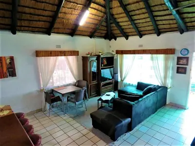 a living room with a couch and a table at Impala Niezel Lodge & Guest House in Hazyview