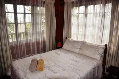 a bedroom with a bed with two towels on it at Impala Niezel Lodge & Guest House in Hazyview