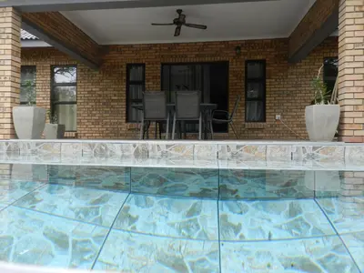 a swimming pool in front of a house at BUFFALO in Marloth Park
