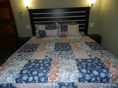 a bed with a quilt on it in a bedroom at BUFFALO in Marloth Park
