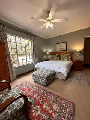 a bedroom with a bed and a ceiling fan at Roosters Nest BnB in Midrand