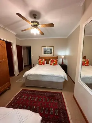 a bedroom with two beds and a ceiling fan at Roosters Nest BnB in Midrand