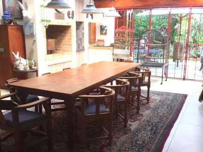 a large wooden table and chairs in a room at Roosters Nest BnB in Midrand