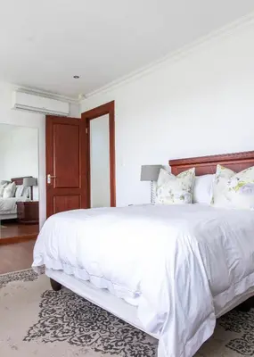 a white bedroom with a large bed with white sheets and pillows at Naledi@53 Private Game Farm in Brits