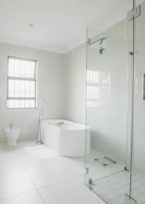 a white bathroom with a tub and a toilet at Naledi@53 Private Game Farm in Brits