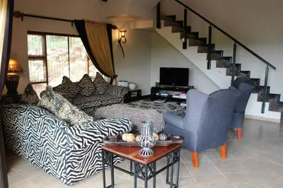 a living room with a zebra print couch and a table at Itaga View, Mabalingwe in Mabula