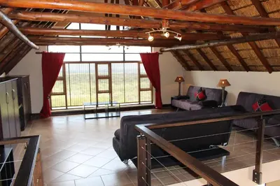 a large living room with a couch and a table at Itaga View, Mabalingwe in Mabula