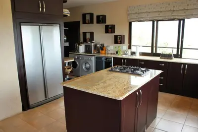 a kitchen with a refrigerator and a stove top oven at Itaga View, Mabalingwe in Mabula