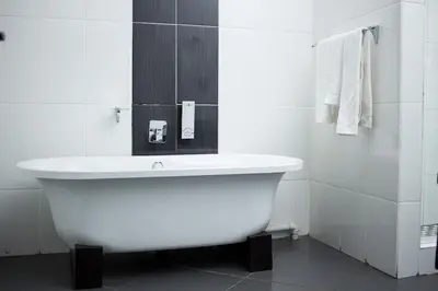 a white bathroom with a white sink and towels at Big Ben Lodge in Polokwane