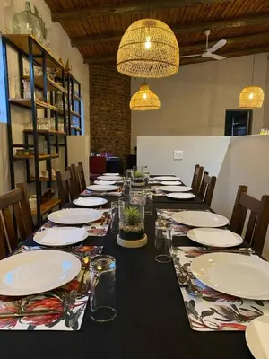 a long table with plates and glasses on it at Gorgeous Gecko Guesthouse in Modimolle