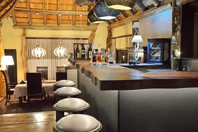 a bar in a restaurant with stools at a counter at Leopard Hills Private Game Reserve in Sabi Sand Game Reserve