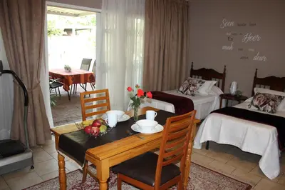 a room with two beds and a table with fruit on it at Little Umhlanga in Pretoria