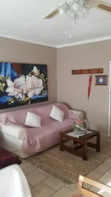 a living room with a pink couch and a table at Little Umhlanga in Pretoria