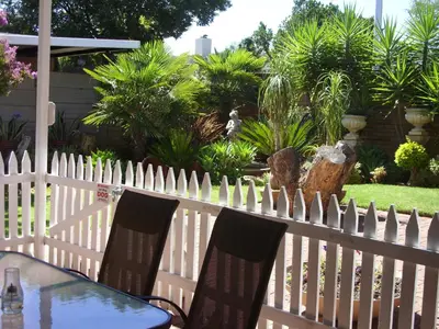 a white picket fence with a table and chairs at Little Umhlanga in Pretoria