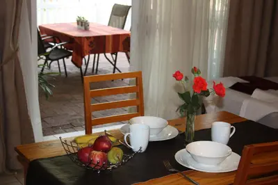 a table with a bowl of fruit and a bowl of flowers at Little Umhlanga in Pretoria